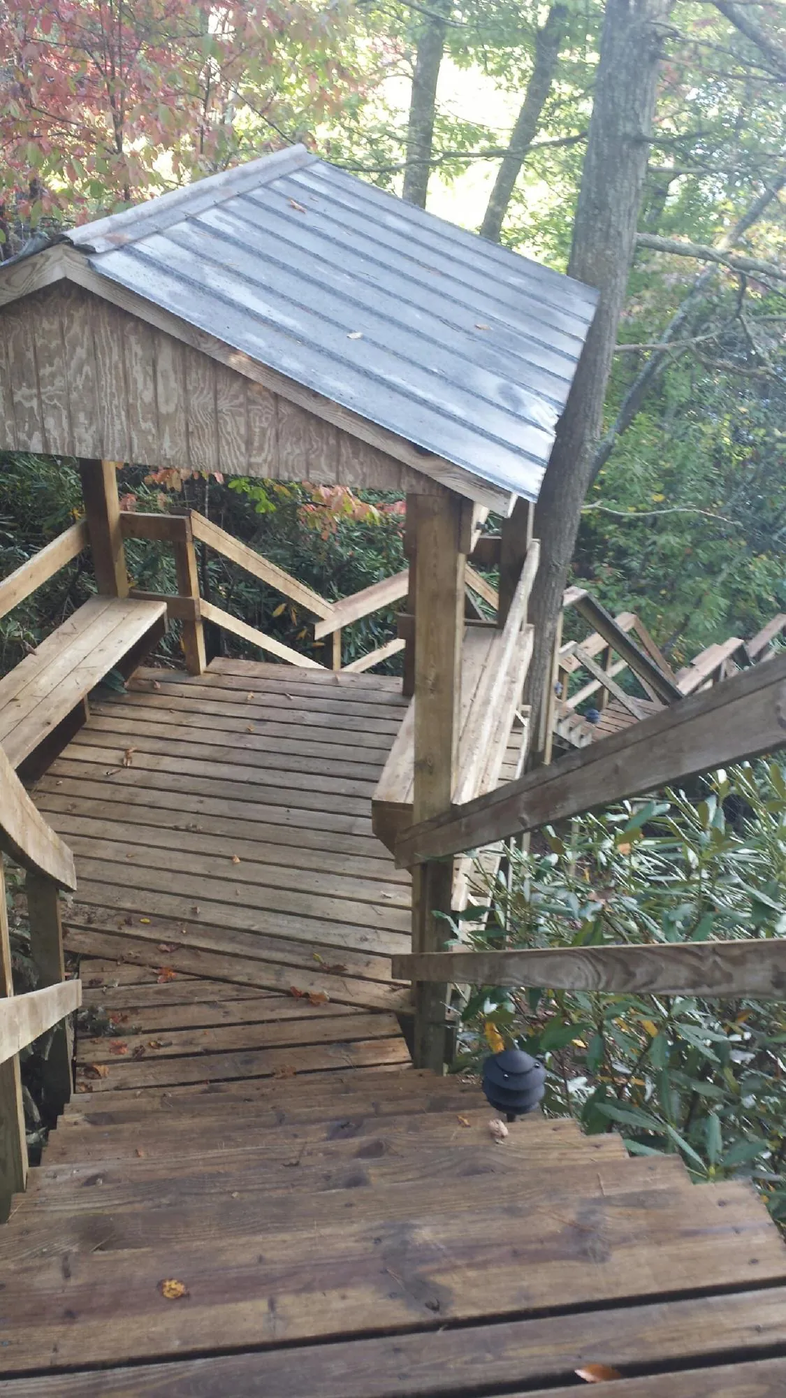 Metal roofed shelter over wooden steps on a wooded walkway — Skylight Repair & Installation work by our crew in Wolcott